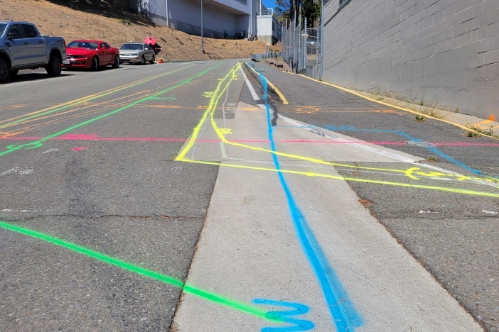 view of a street with colored lines indicating utility locations